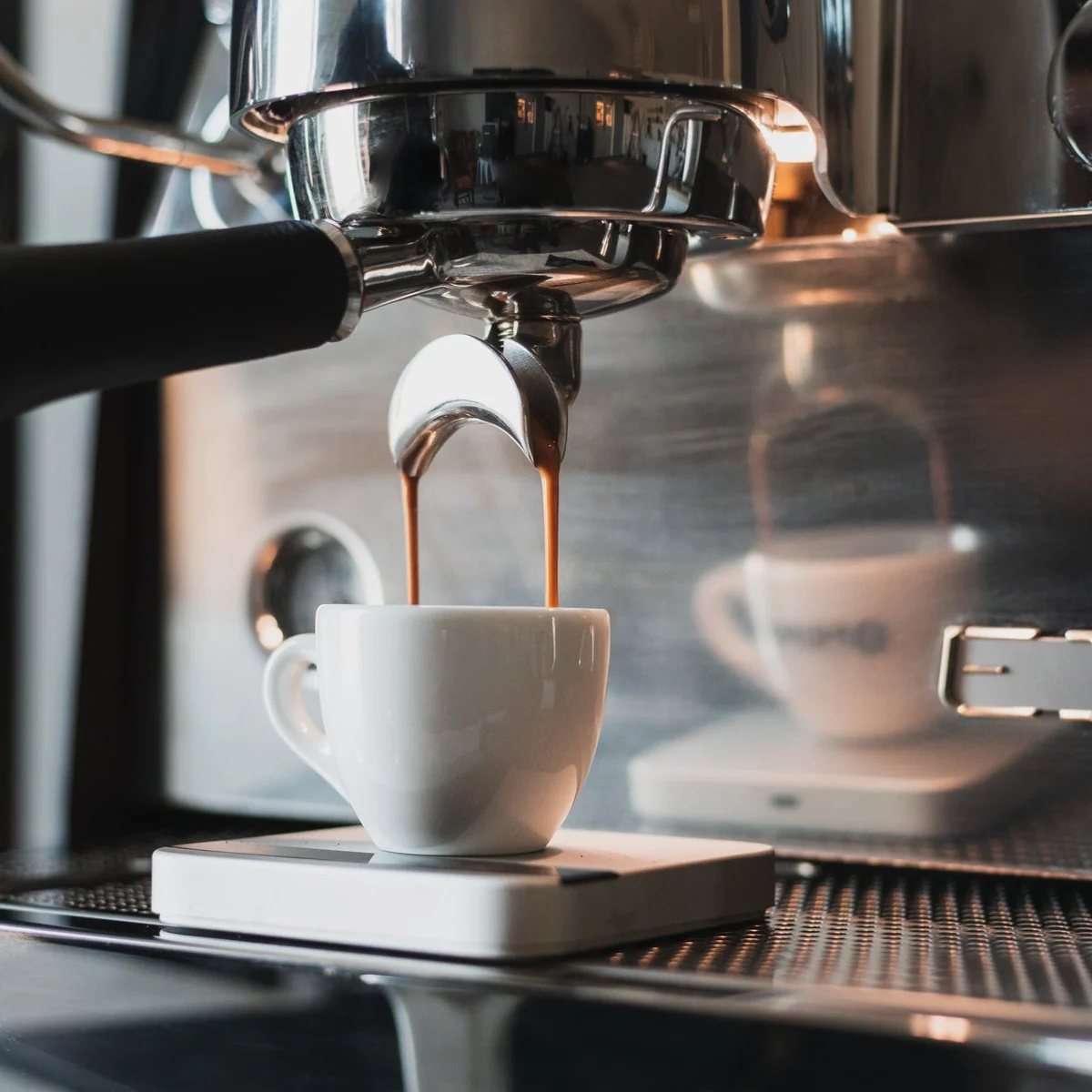 Espresso pouring from the Victoria Arduino Eagle One Prima group into a white cup on a scale