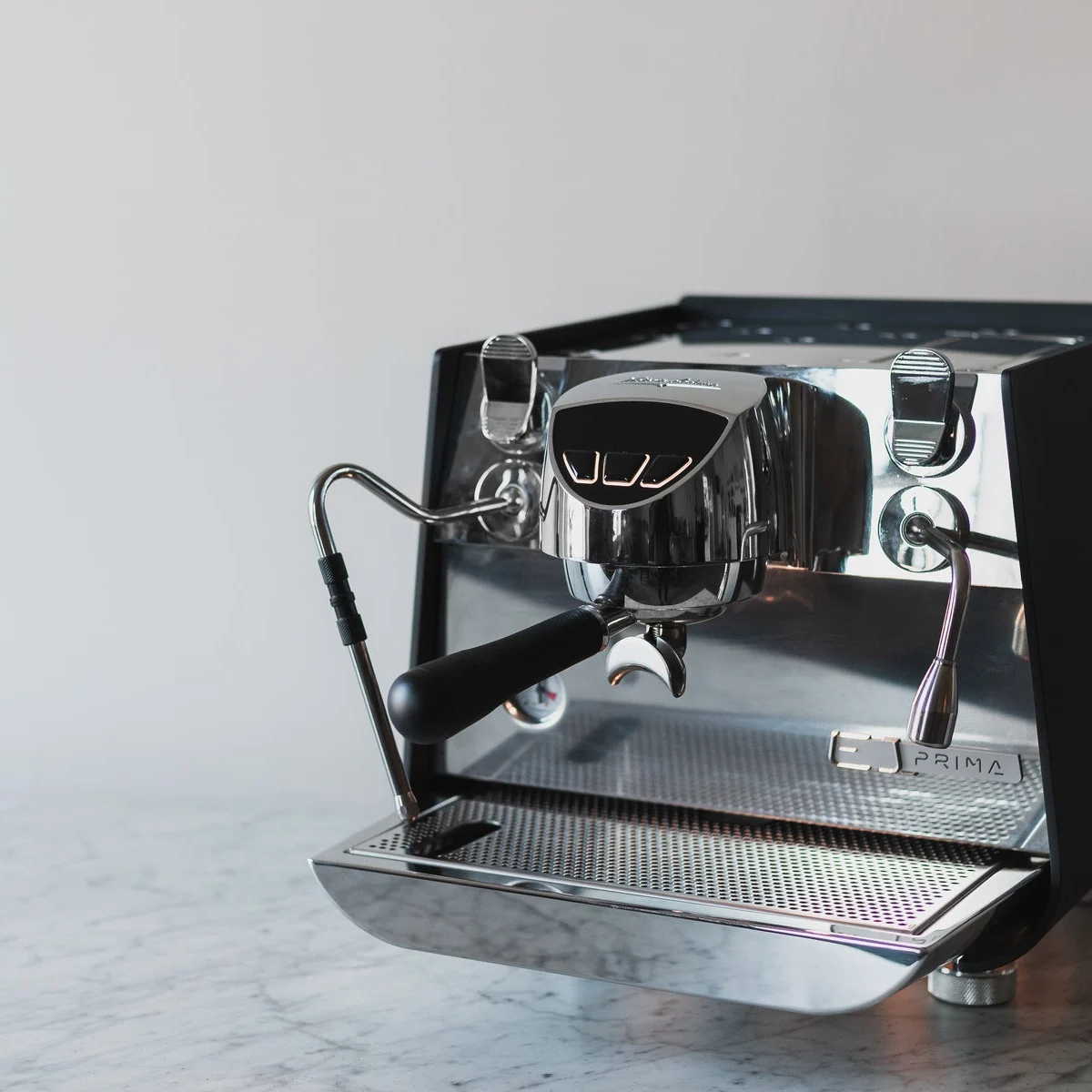 Victoria Arduino Eagle One Prima, black with polished steel front, on a marble bench